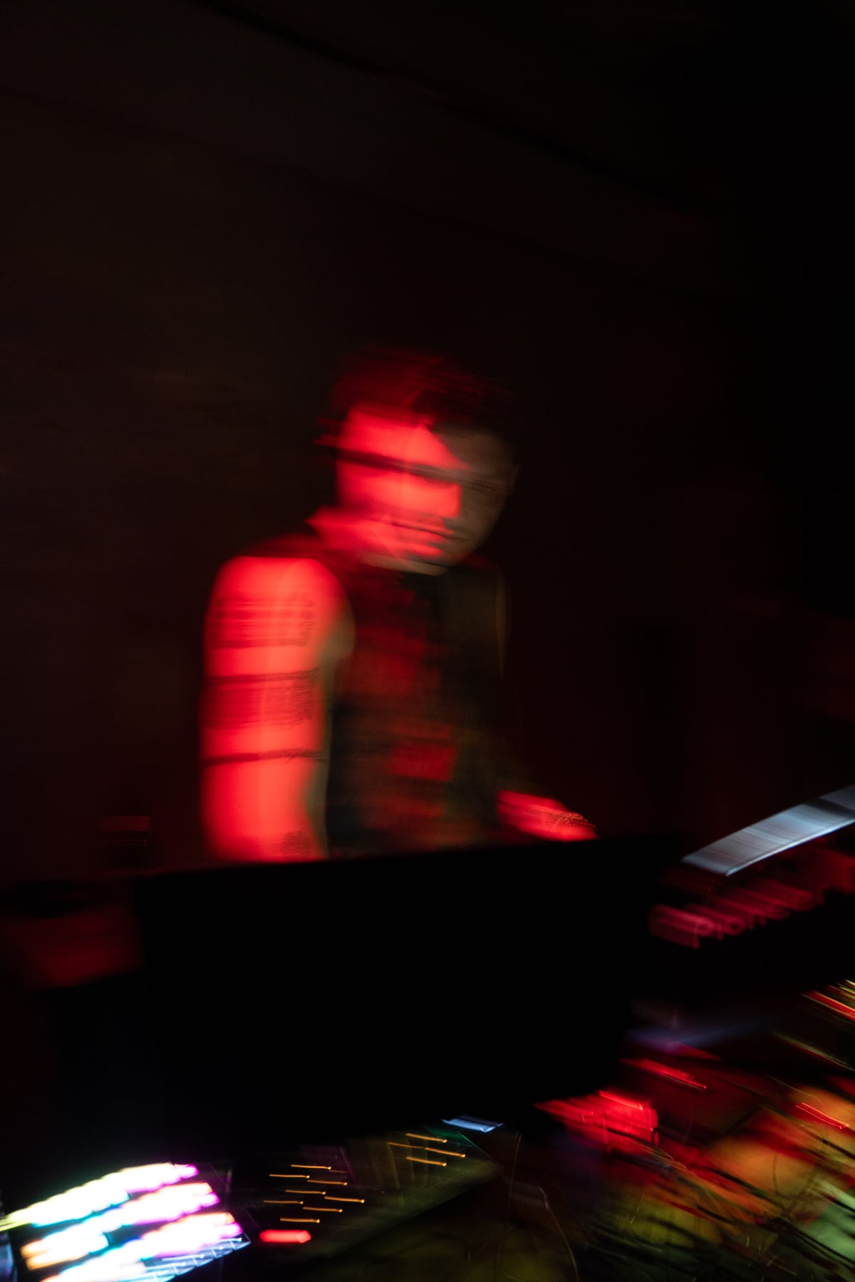 赤い光に包まれて演奏するDJ